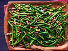 green beans and bacon on a wooden platter with a red checkered table cloth