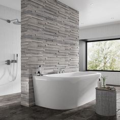 a large white bath tub sitting next to a window