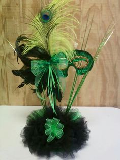 a vase filled with green and black feathers