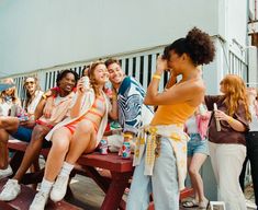 a group of women sitting on top of a wooden bench