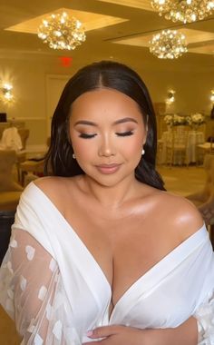 a woman in a white dress with her hands on her chest and eyes closed, posing for the camera