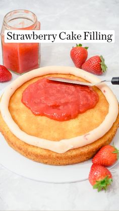 there is a cake with strawberry jam on it and some strawberries next to it