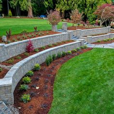 an outdoor garden with stone walls and green grass