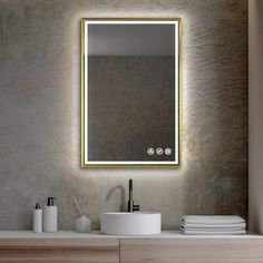 a bathroom with a sink, mirror and towels on the counter top in front of it