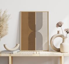 a table with two vases and a book on it next to a wall mounted art piece