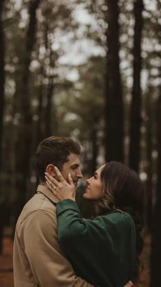 a man and woman embracing in the woods