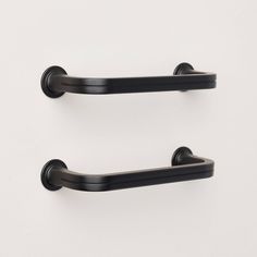 two black metal handles on a white wall