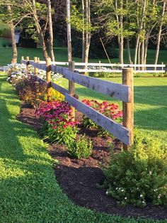 a wooden fence surrounded by flowers and trees