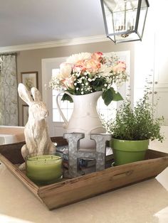 a tray with flowers and candles on top of a table next to a bunny figurine