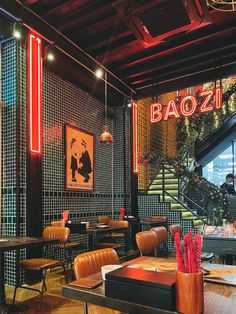 the interior of a restaurant with tables, chairs and artwork on the wall behind them