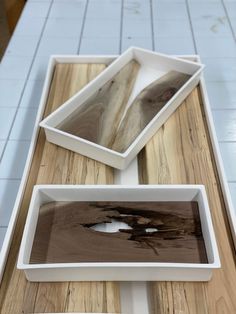 three white bowls sitting on top of a wooden table