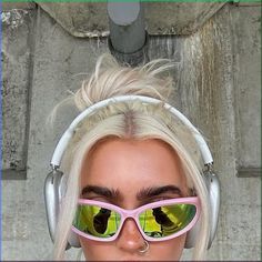 a woman wearing headphones and pink sunglasses