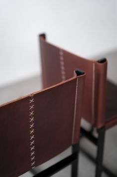 two brown leather chairs sitting next to each other