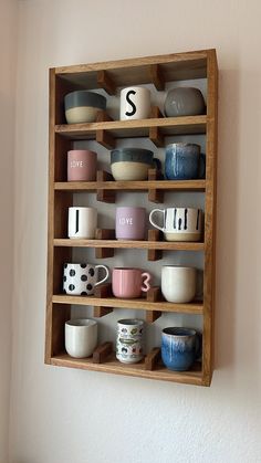 a wooden shelf filled with cups and bowls