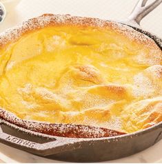 a pie sitting on top of a pan covered in powdered sugar