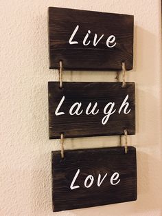 three wooden signs that say live laugh love