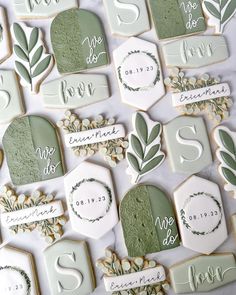 cookies decorated with green and white icing are arranged on the table for guests to eat