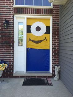 a yellow and blue door decorated with a cartoon character on it's front porch