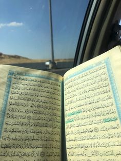 an open book sitting in the passenger seat of a car with arabic writing on it