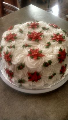 a decorated cake sitting on top of a table next to a plate with red and white frosting