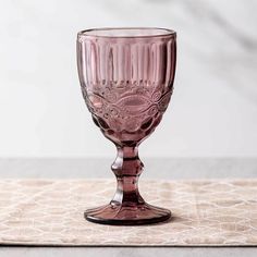 a pink wine glass sitting on top of a table