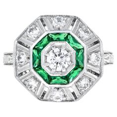 An 18k white gold Art-Deco design diamond and emerald target ring, a center diamond with an outer ring of round diamonds an inner one of French cut emeralds and finished with millgrain edging, finished with diamond shoulders. Ring Information Style: Art Deco Metal: 18K White Gold Weight: 4.00 g. (approx. total weight) Center Gemstones Type: Diamond Shape: Round Average Color: H Average Clarity: SI Size: 4 mm. Number: 1 Weight: 0.25 Carat (approx. total weight) Accent Gemstones I Type: Diamond Sh Target Ring, Dragon Hoard, Ladies Accessories, Chartreuse Green, Adorable Outfits, Family Jewels, Art Deco Engagement, Gold Art Deco, Big Rings