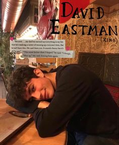 a man sitting at a table with his head on his hands and the words david eastman king above him