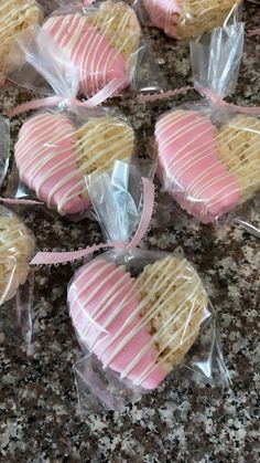 heart shaped cookies wrapped in cellophane and tied with pink ribbon on granite countertop