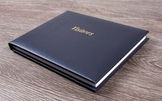 a black book sitting on top of a wooden table