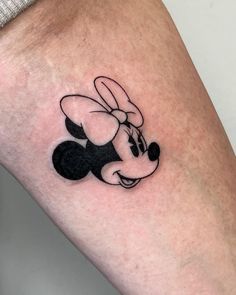 a small mickey mouse tattoo on the leg