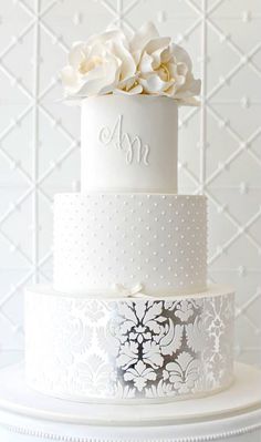 a three tiered cake with white flowers on top