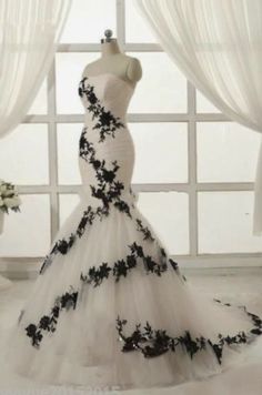 a white and black wedding dress on display in front of a window