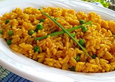 a white plate topped with yellow rice and peas