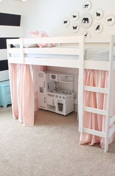 there is a bunk bed with pink curtains on the top and bottom, next to a play kitchen