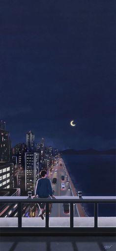 a man sitting on top of a balcony next to the ocean at night with city lights in the background