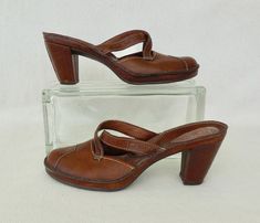 "This is a Gorgeous pair of Leather Mules. They are a dark brown leather slip on mule with a strappy boot stitch. These clogs have a cushioned insole with a leather wrapped high heel and a non slip rubber platform sole. They have barely been worn and are in Excellent Condition! Label: CLARK'S ARTISAN COLLECTION Size: Women's 7 9 1/4\" Length Toe to Heel 3 1/4\" Width Widest Part of Sole 3\" Heel Cleaned and Conditioned ready to wear. Visit my shop for your wardrobe and accessories. www.etsy.com/ Formal Brown Clogs With Leather Footbed, Brown Leather Slip-on Clogs, Vintage Brown Mules With Leather Sole, Vintage Brown Leather Mules, Vintage Brown Mules With Leather Footbed, Formal Brown Clogs With Wooden Heel, Chic Cowgirl, High Heel Clogs, Hippie Boots