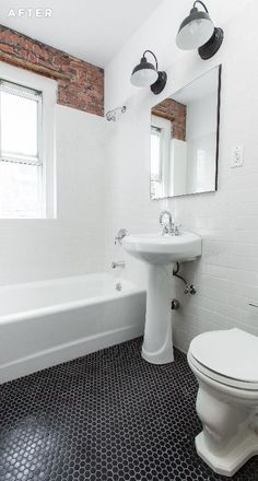 a white toilet sitting next to a bath tub under a bathroom mirror on top of a black and white tiled floor