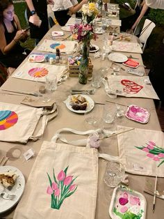 a long table is set up with place settings and napkins for an art party