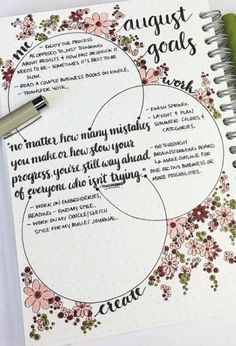 a spiral notebook with the words august goals on it and a pen next to it