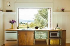 a kitchen with an open window and lots of counter space in front of the sink