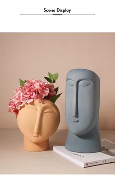 two vases with flowers in them sitting next to each other