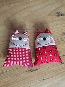 two pillows made to look like cats sitting on top of a wooden floor next to each other