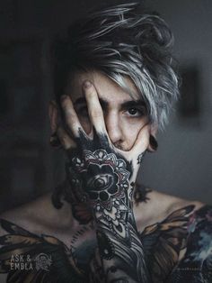 a woman with tattoos covering her face and hands