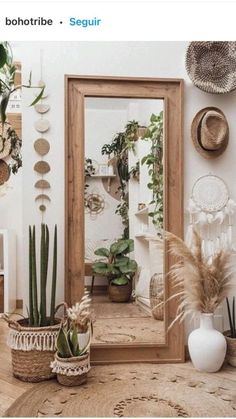 a room filled with lots of potted plants on top of a wooden table next to a mirror