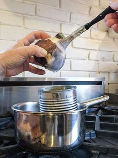 someone is cooking food on the stove with a spatula in their hand while another person holds it up