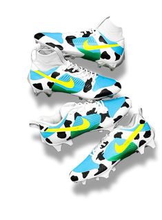 three pairs of soccer shoes with cow print on the upper and lower part of each shoe