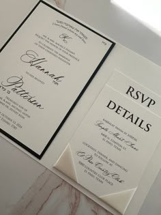 two black and white wedding cards on a table