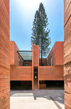 the entrance to an orange building with trees in the background