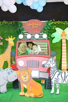 children are sitting in the back of a car decorated with animals and giraffes