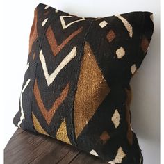 a black and brown pillow sitting on top of a wooden table